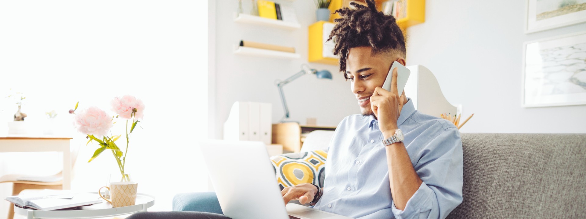 man on the phone while using laptop