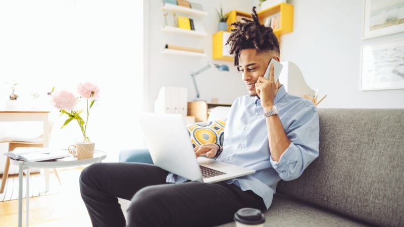 man on the phone while using laptop